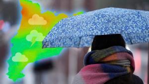 Una mujer se protege con un paraguas de la lluvia
