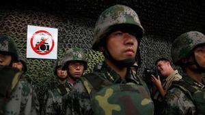 Militars xinesos posen davant d’un cartell que prohibeix les fotografies a Pequín.